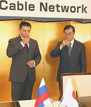 Генеральный директор "Ростелекома" Константин Солодухин (слева) и президент KDDI Тадаши Онодера (справа) обмывают подводный кабель.