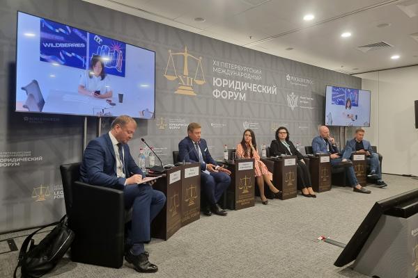 ПМЮФ 2024. На фото слева направо: модератор Денис Косенков, президент Ассоциации компаний интернет-торговли Артем Соколов, заместитель генерального директора фонда "Центр стратегических разработок" Екатерина Папченкова, ректор Саратовской государственной юридической академии Екатерина Ильгова, председатель организации по защите прав потребителей "Общественная потребительская инициатива" Олег Павлов, декан факультета права НИУ ВШЭ Вадим Виноградов. На экране генеральный директор Wildberries Татьяна Бакальчук